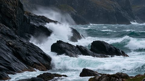A dramatic, wide shot of powerful ocean waves violently crashing against dark, jagged rocks along a misty Scottish coastline.
